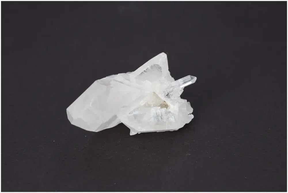 Rough Crystal Quartz Cluster on black background showcasing its natural beauty and spiritual energy-enhancing properties.