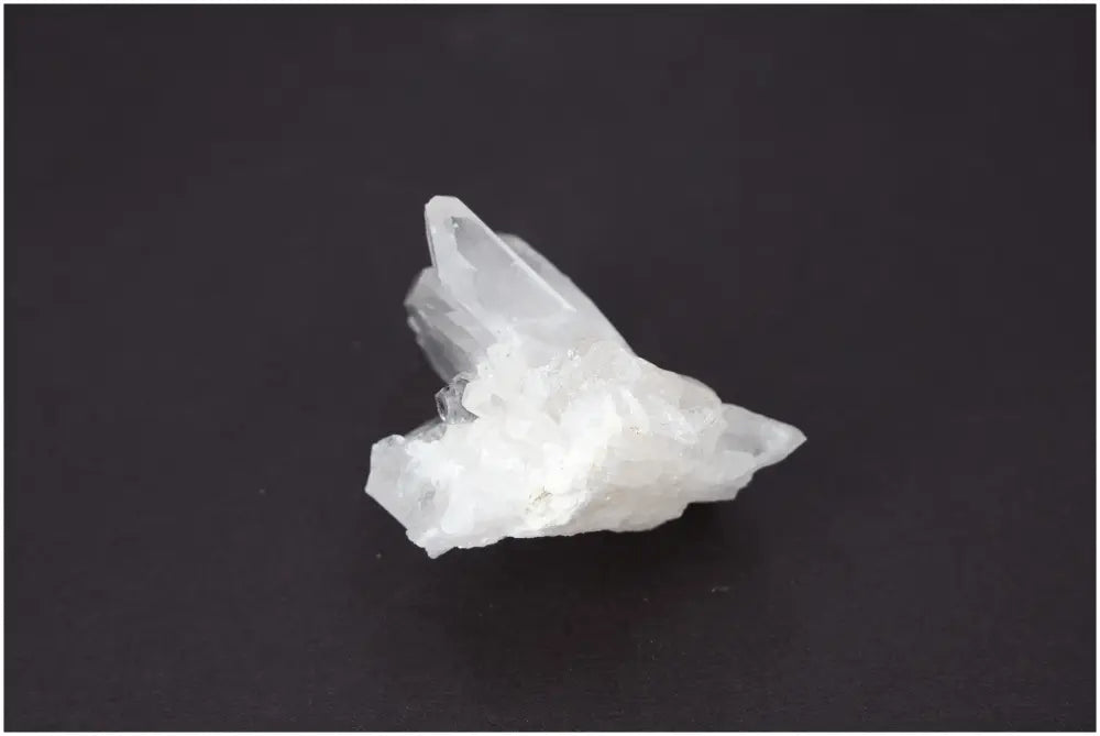 Rough crystal quartz cluster showcasing natural beauty and spiritual energy against a dark background.