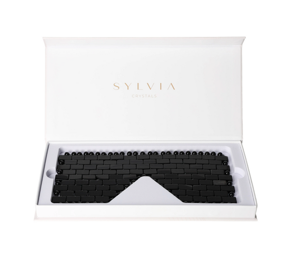 Obsidian Eye Mask 635387 in white SYLVIA CRYSTALS packaging, showcasing sleek black design for detoxification and revitalization.