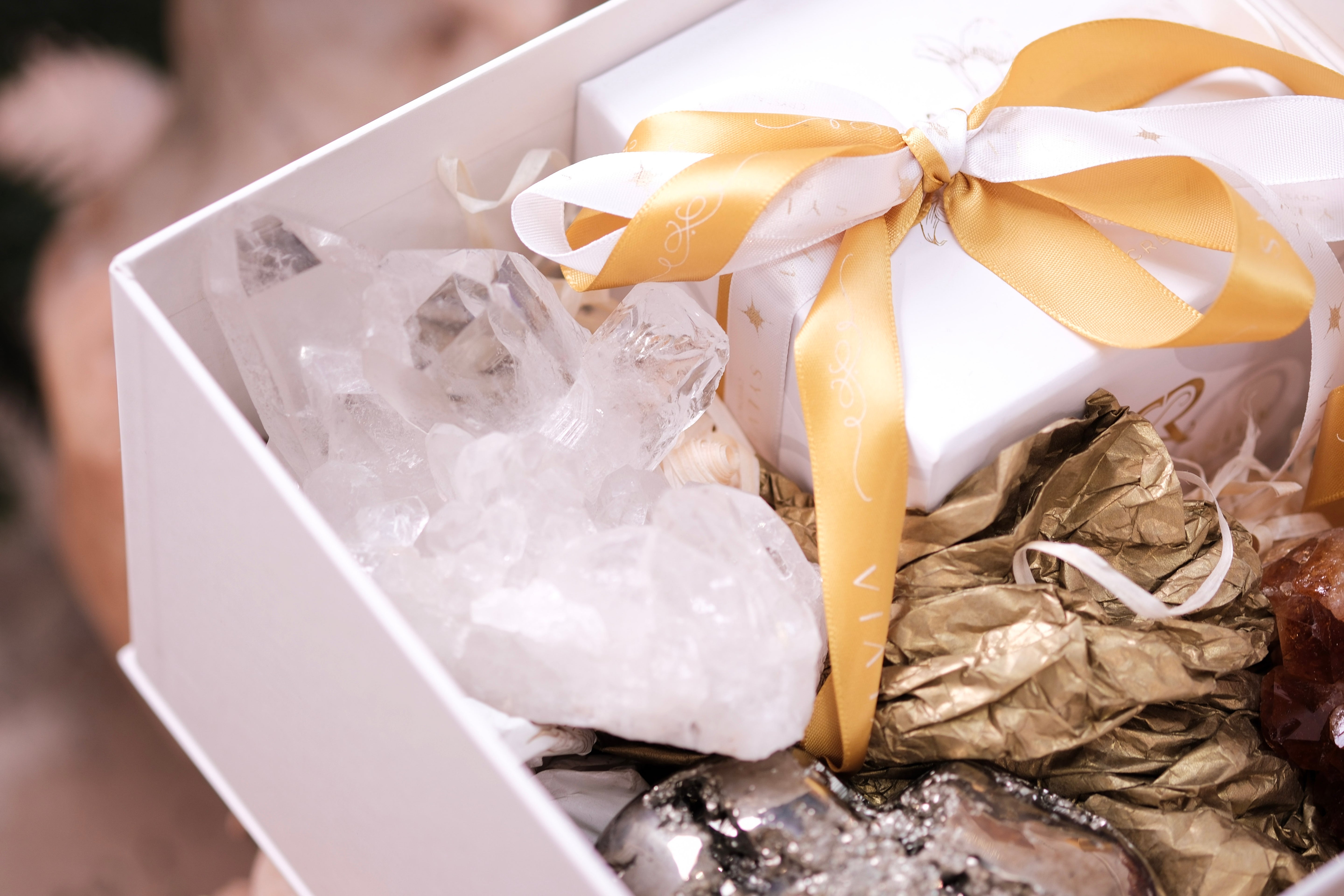 Deluxe Christmas Box featuring crystals and a candle for wealth and abundance with gold ribbon packaging.