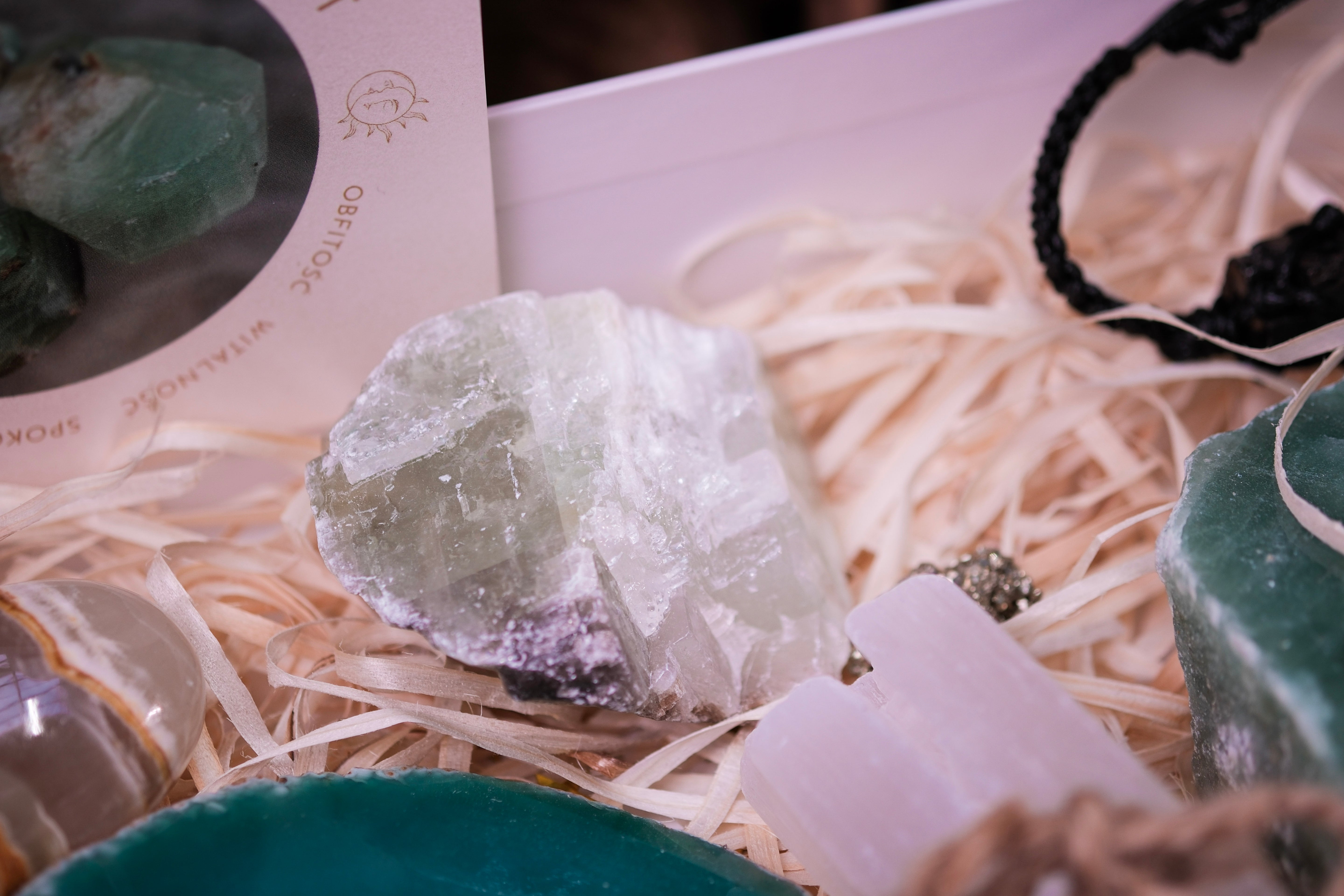 Christmas crystal gift box with green and white crystals on straw bedding, perfect for holiday gifting and inspiring positivity.