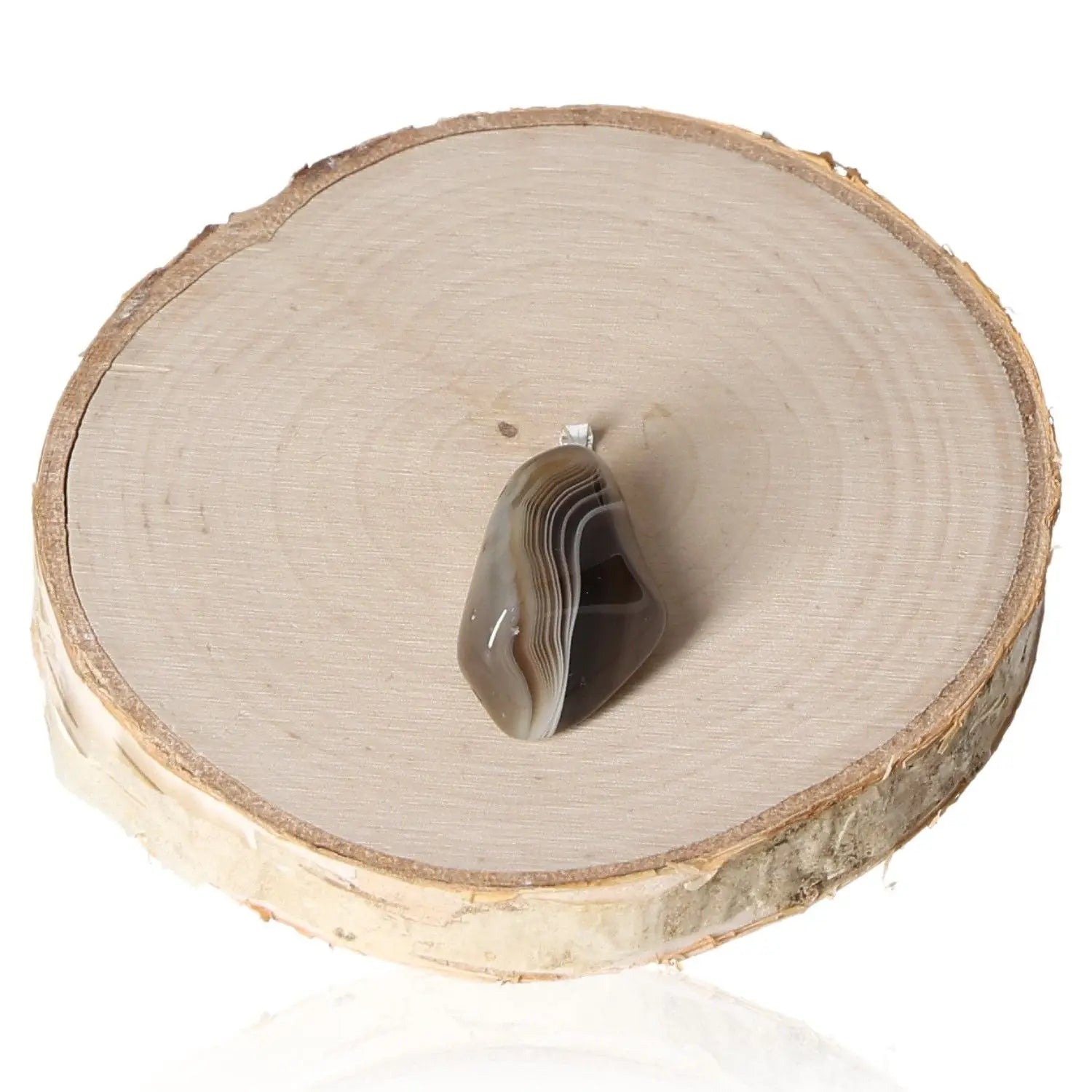 Agate Grey Tumbled Pendant with natural grey hues on wooden display, showcasing its smooth finish and elegant design