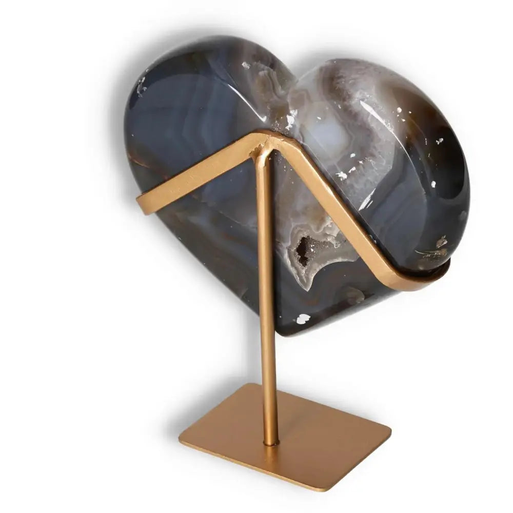 Heart-shaped agate sculpture with natural veining on a gold stand, highlighting its elegant patterns and translucency.