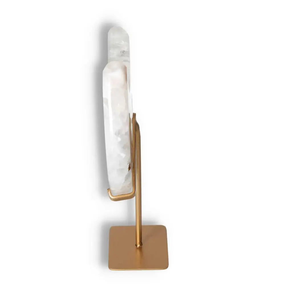 Side view of an agate lunar crescent on a gold stand, showcasing its ethereal off-white swirls and unique geode formation.