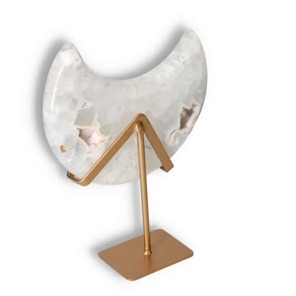 Agate lunar crescent with translucent swirls on a golden stand, showcasing natural geode formation and celestial elegance.