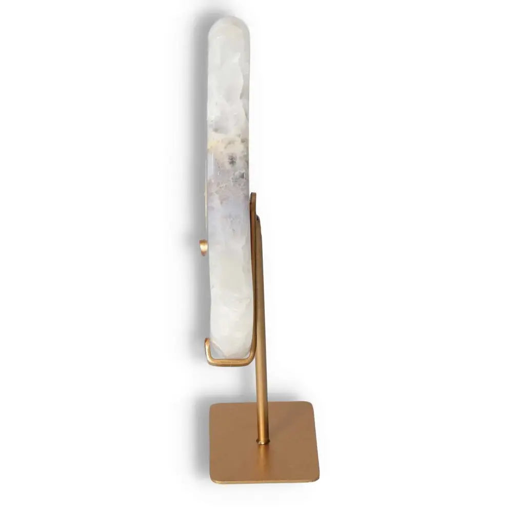 Side view of agate lunar crescent sculpture on a metal stand, showcasing its translucent layers and natural geode center.