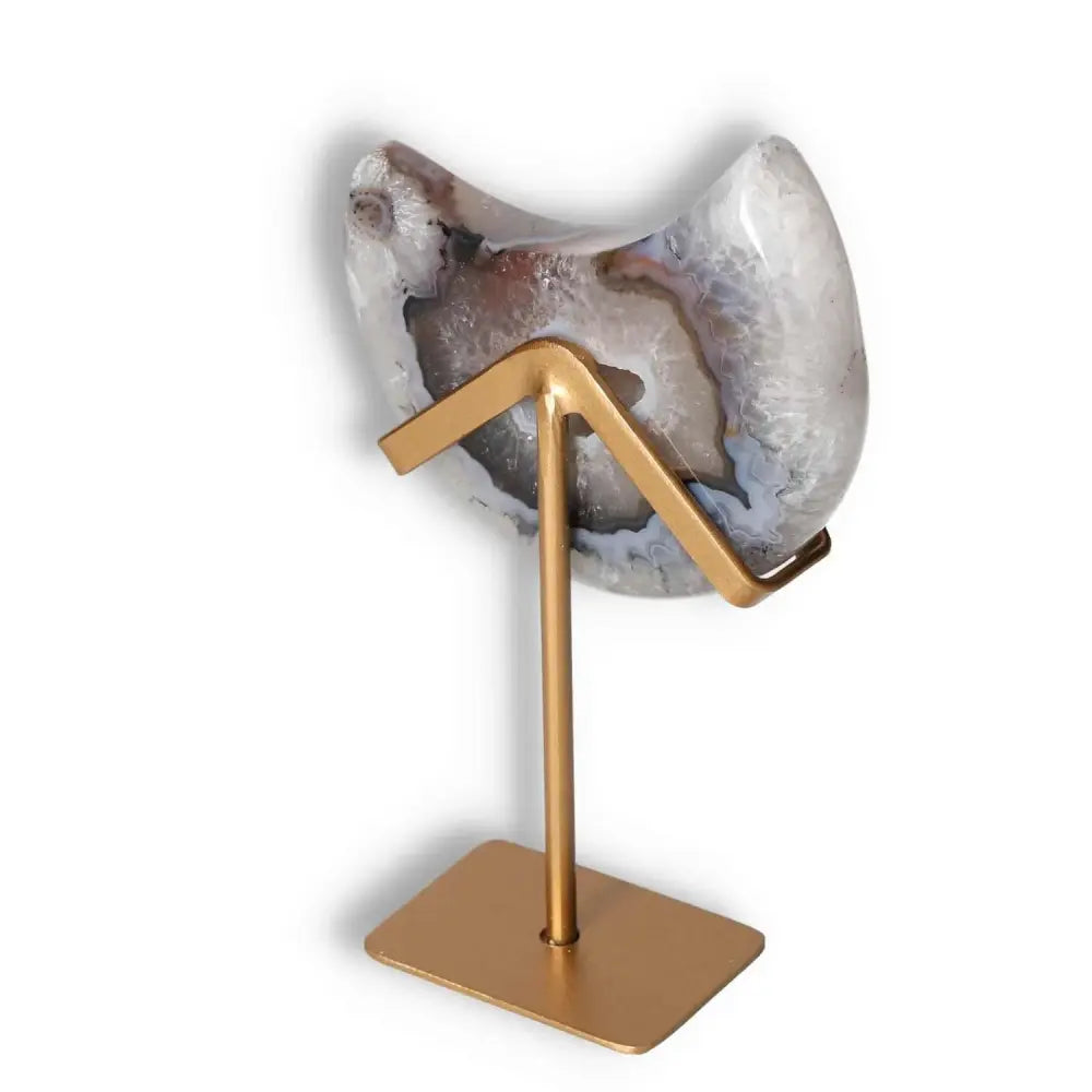 Agate lunar crescent sculpture with natural geode on gold stand, highlighting translucent swirls and celestial elegance.