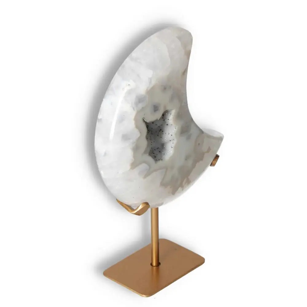Agate lunar crescent with geode center on a metal stand, featuring swirling off-white hues and translucent layers, showcasing natural elegance.