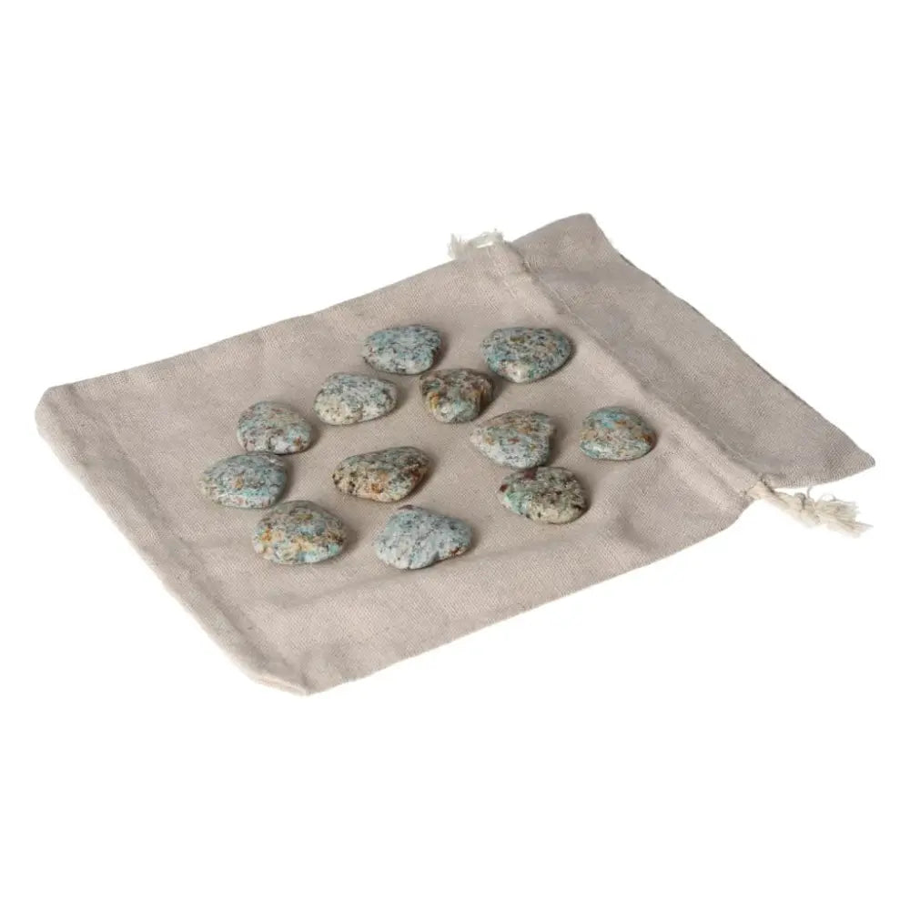 Small amazonite heart stones on a beige pouch, known for releasing fear and balancing emotions for a calming effect.