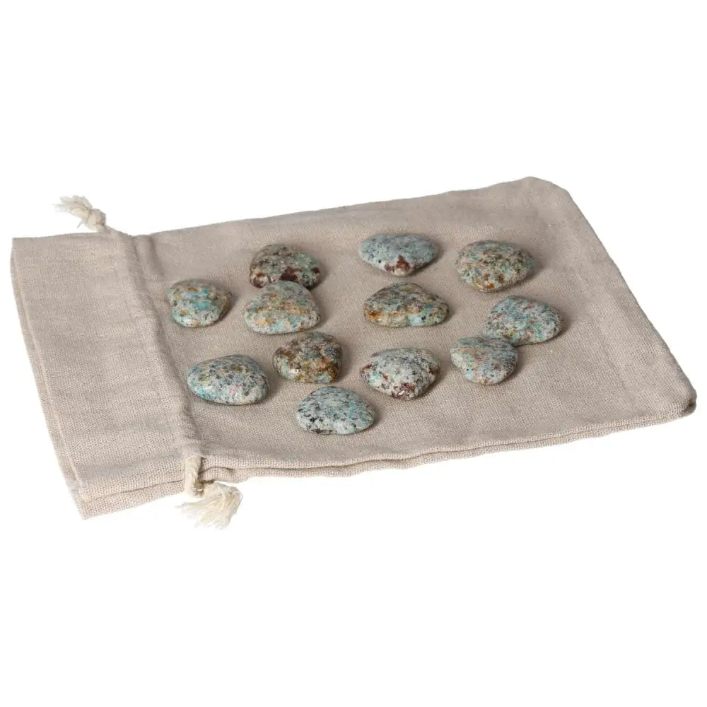 Collection of amazonite small heart stones on a beige cloth, symbolizing harmony and security, ideal for balancing emotions.
