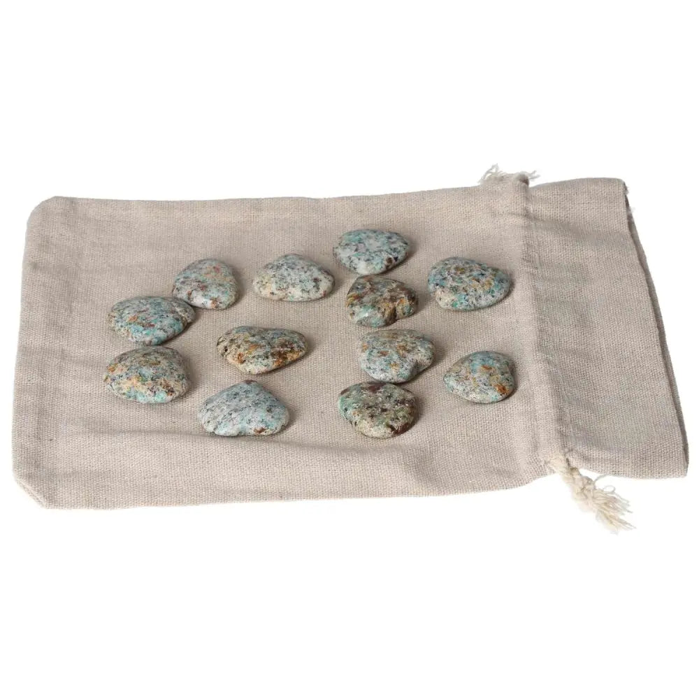 Amazonite small heart stones on a beige cloth, known for harmony and emotional balance, offering a calming effect and security.