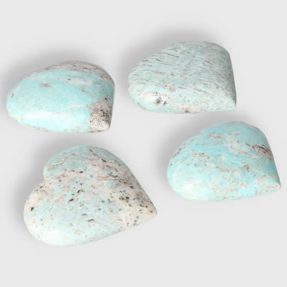 Set of four Amazonite heart-shaped gemstones in soothing turquoise and green shades, promoting emotional balance and clear communication.