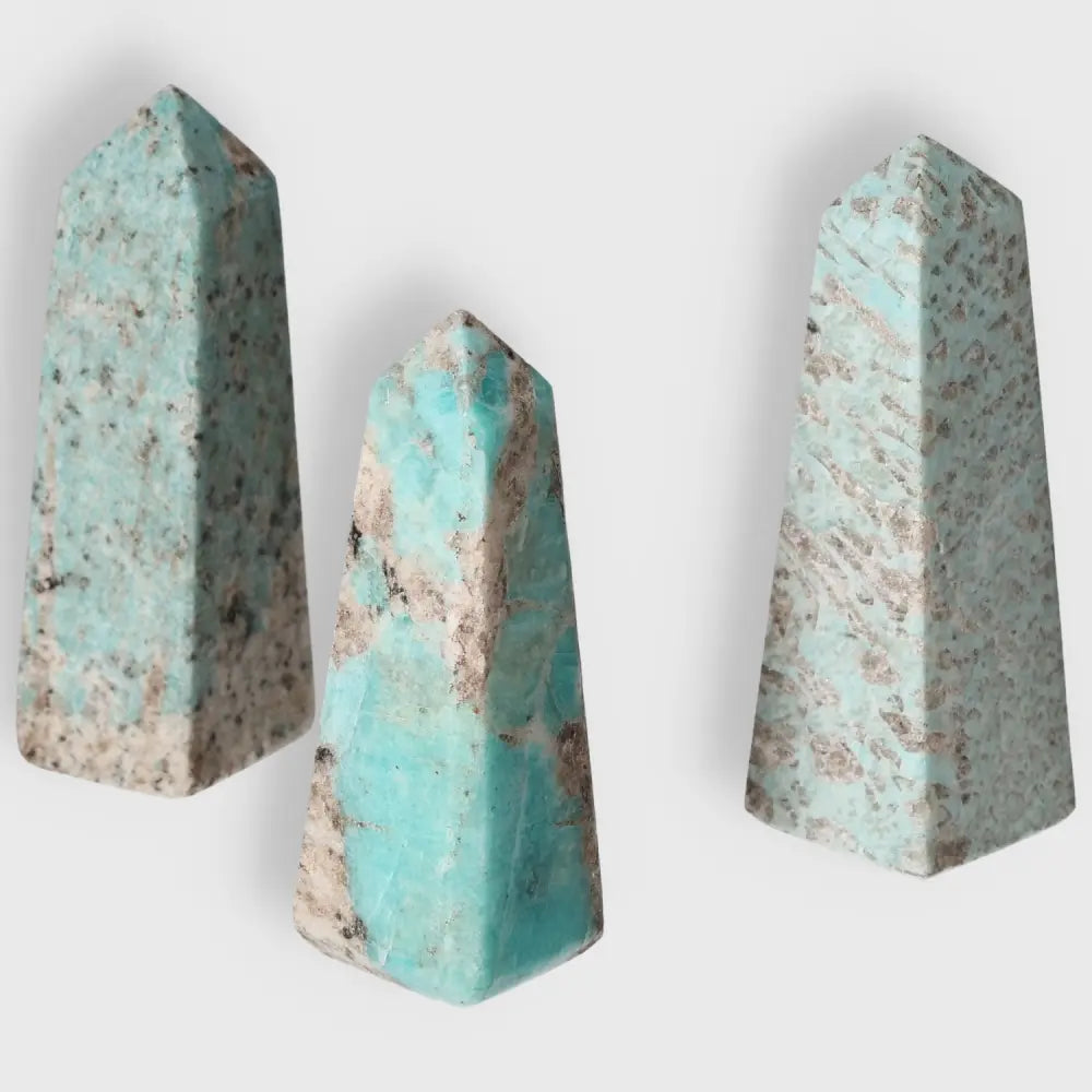 Three Amazonite towers with unique turquoise and green patterns, symbolizing courage and truth, perfect for emotional balance and communication.