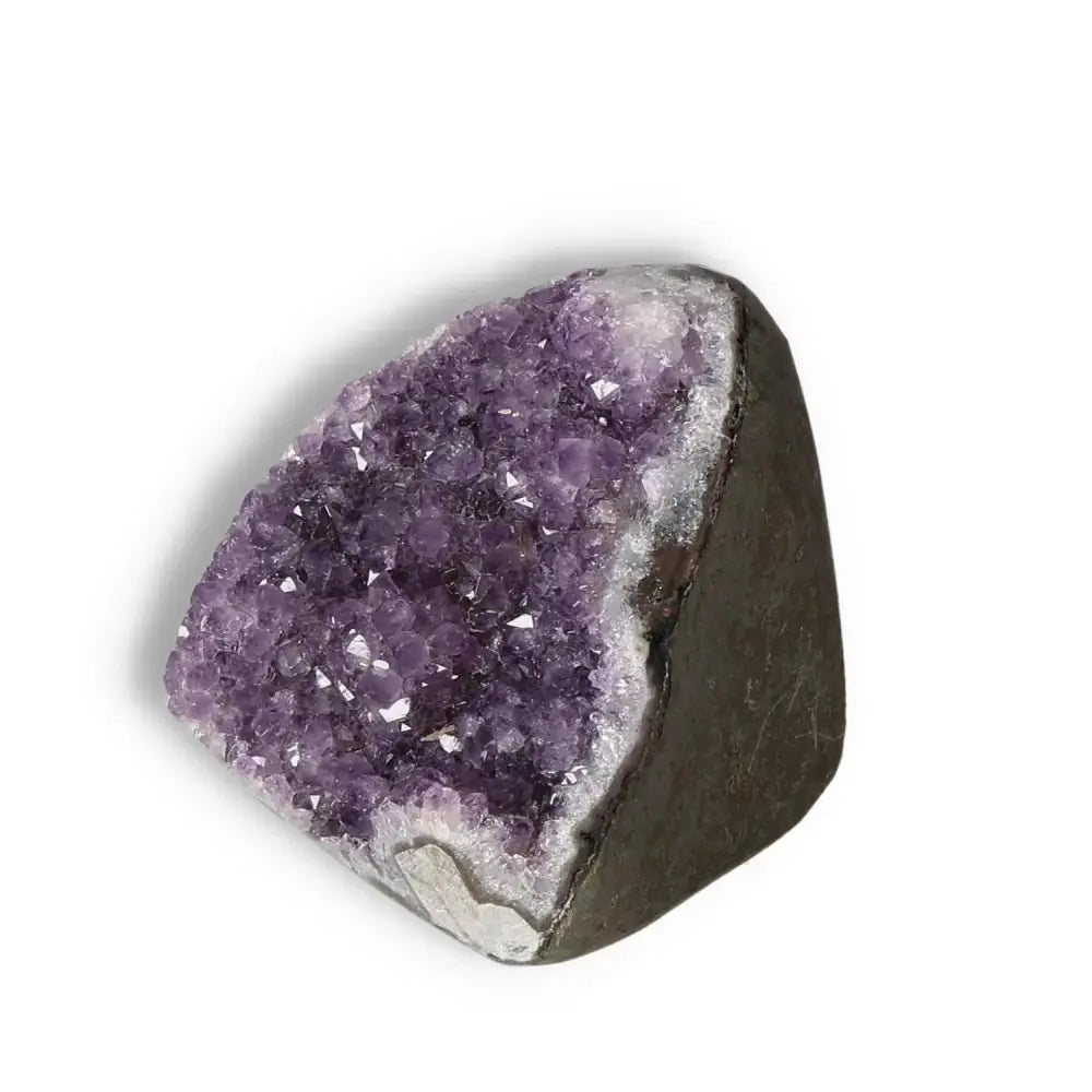Amethyst cut base geode from Sylvia Crystals, showcasing vibrant purple crystals and rocky base, known for calming and energy-boosting properties.