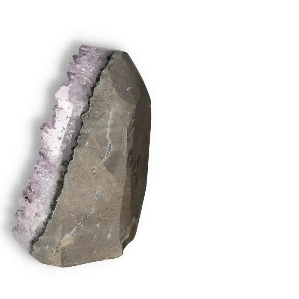 Side view of a Sylvia Crystals premium Amethyst Cut Base Geode displaying its elegant purple hues and natural stone base.