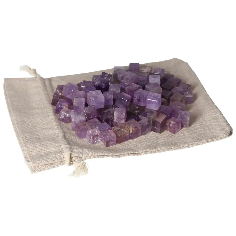 Amethyst small cubes on beige cloth, known for reducing stress and enhancing concentration, providing emotional stability and energy boost.