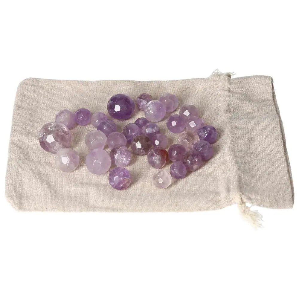 Amethyst small geometric spheres on a fabric pouch, ideal for stress reduction, energy boost, concentration enhancement, and emotional stability.