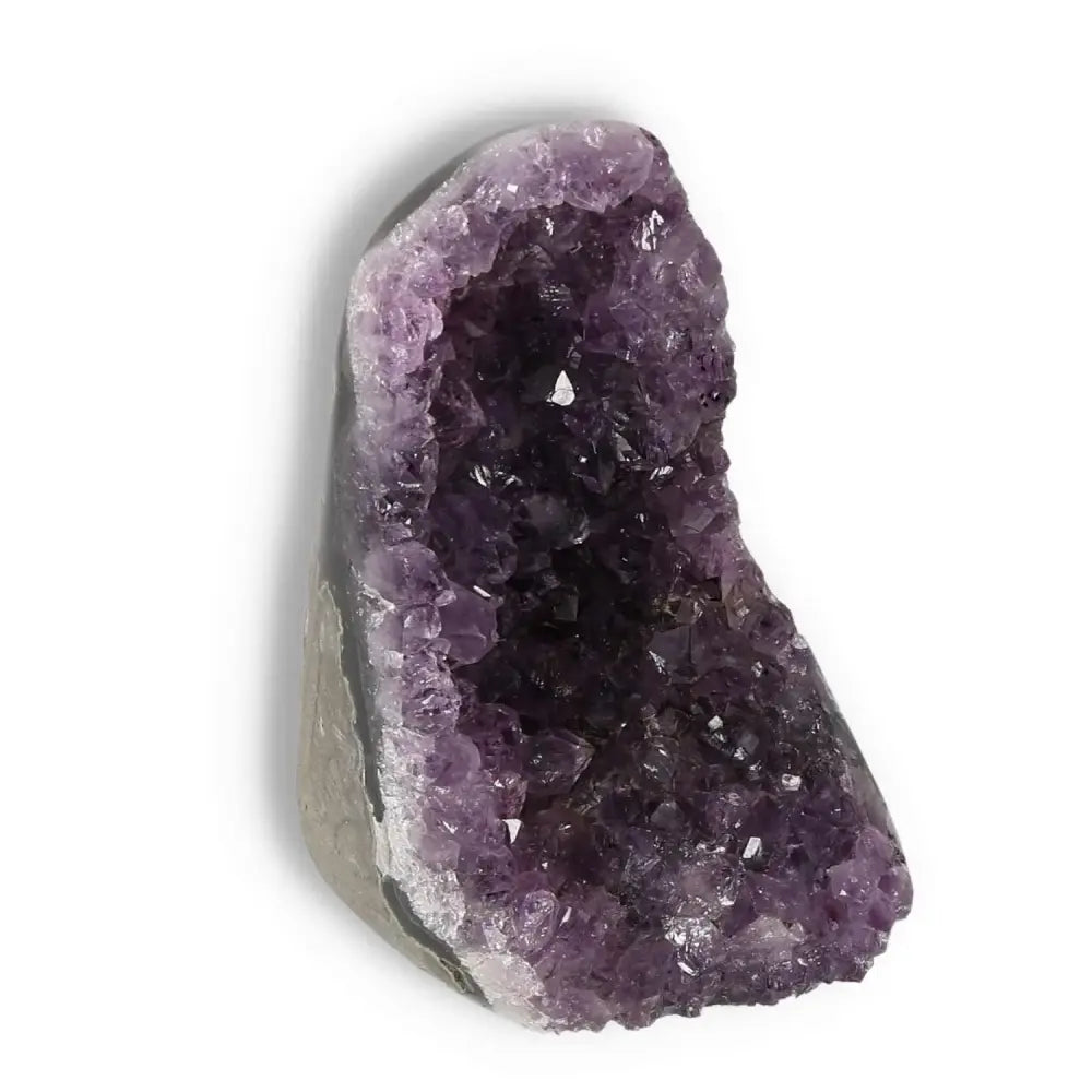 Amethyst cut base geode from Sylvia Crystals, known for reducing stress and boosting energy, featuring calming purple crystals.