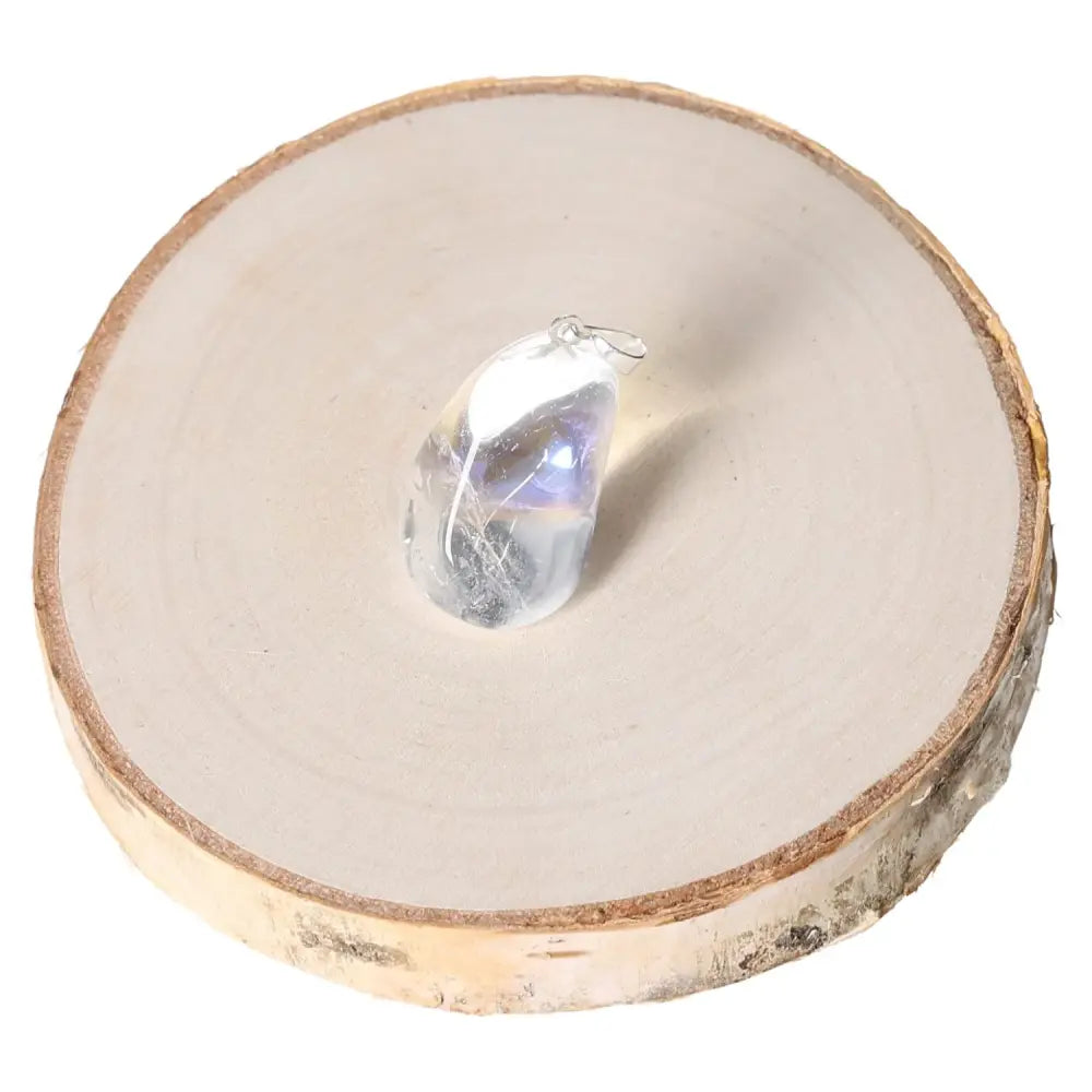 Angel Aura Tumbled Pendant with ethereal luminescent hues on a wooden slice display.