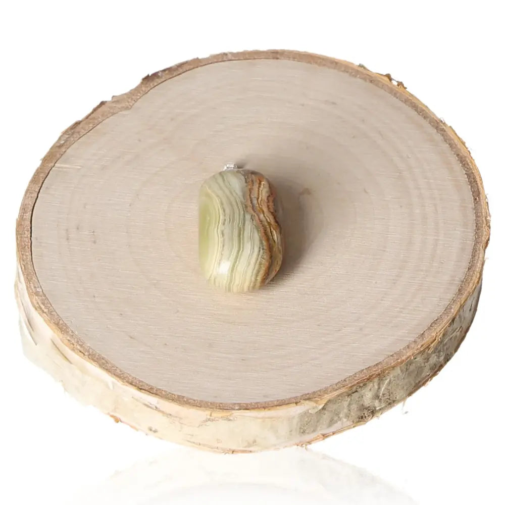 Aragonite tumbled pendant on wooden base, showcasing natural gemstone beauty and spiritual enhancement properties.