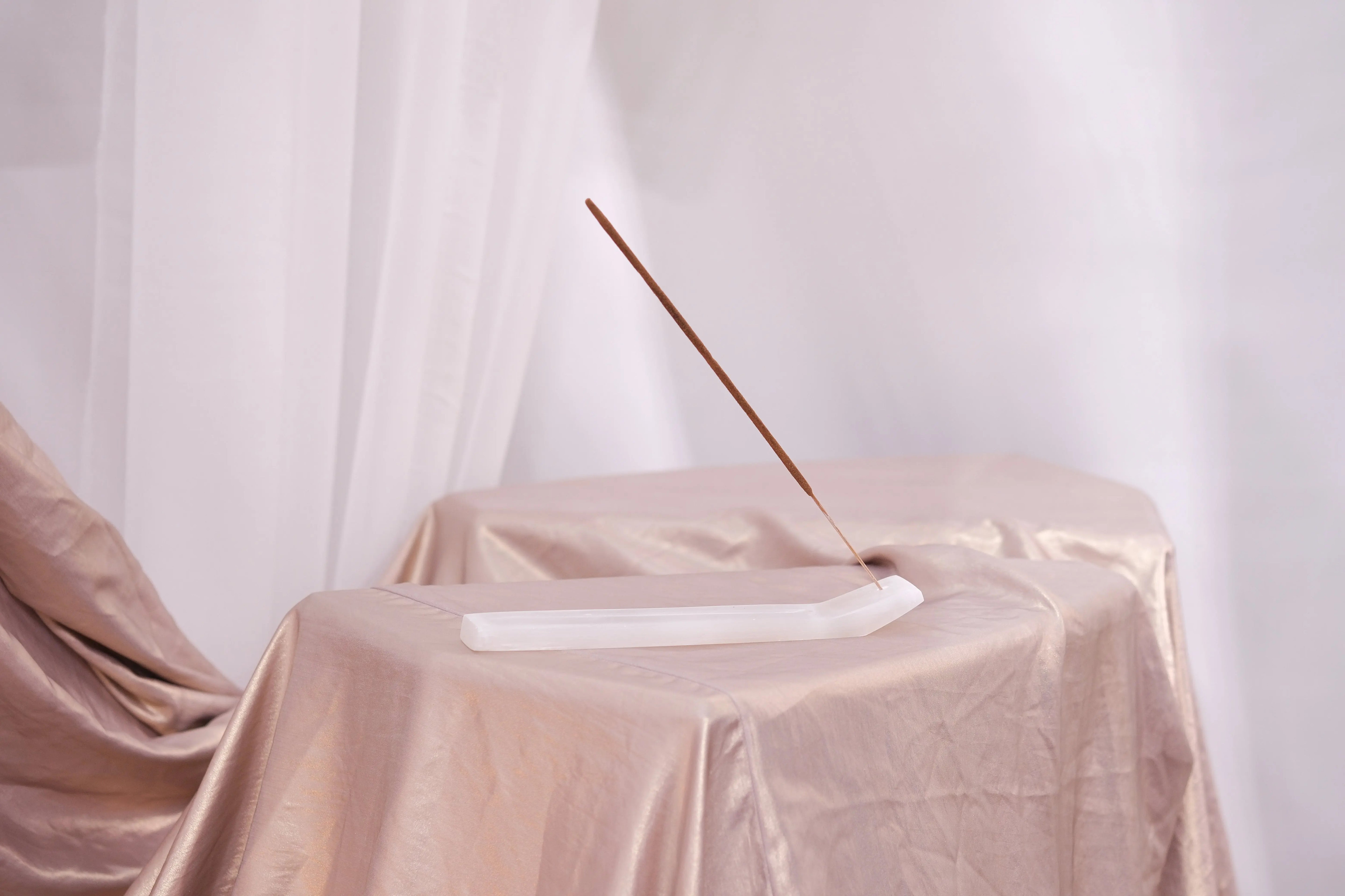 Elegant display of Bali Harmony Incense Blend stick on a satin-draped table, embodying serenity and traditional Balinese craftsmanship.