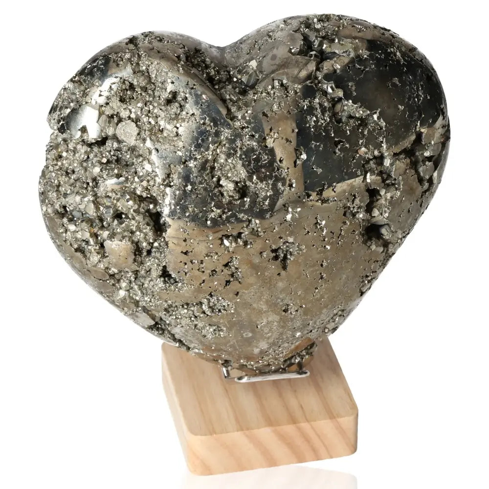 Shiny heart-shaped pyrite stone on a wooden stand, symbolizing courage and initiative, ideal for mental and material independence support.