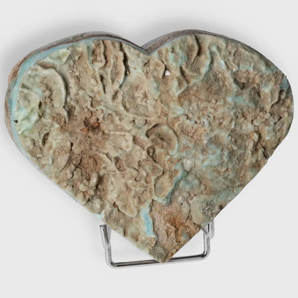 Heart-shaped Blue Aragonite crystal with textured surface on display stand, offering calming energy and emotional balance benefits.