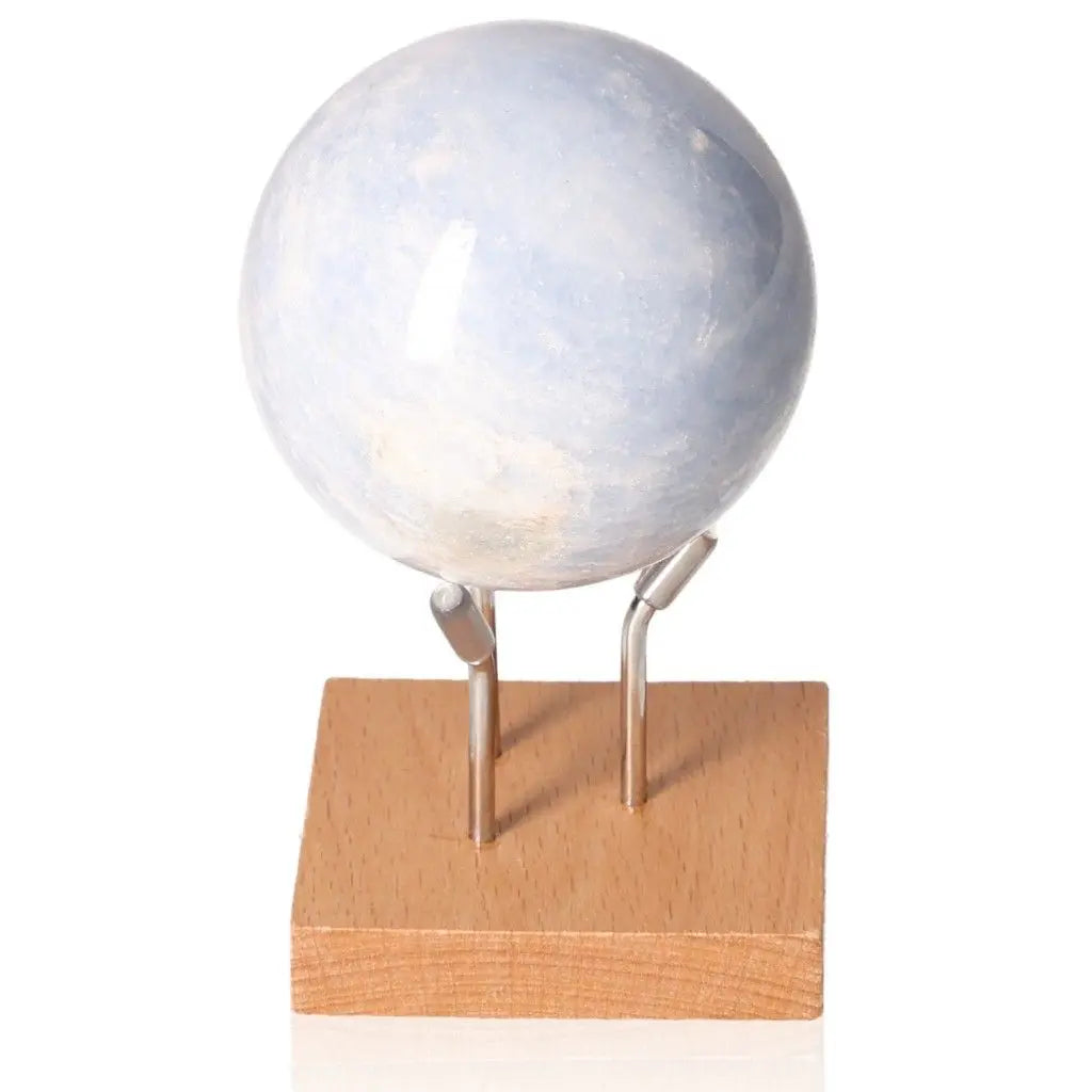 Blue Calcite Sphere for stress relief, emotional healing, and enhanced communication shown on a wooden stand.