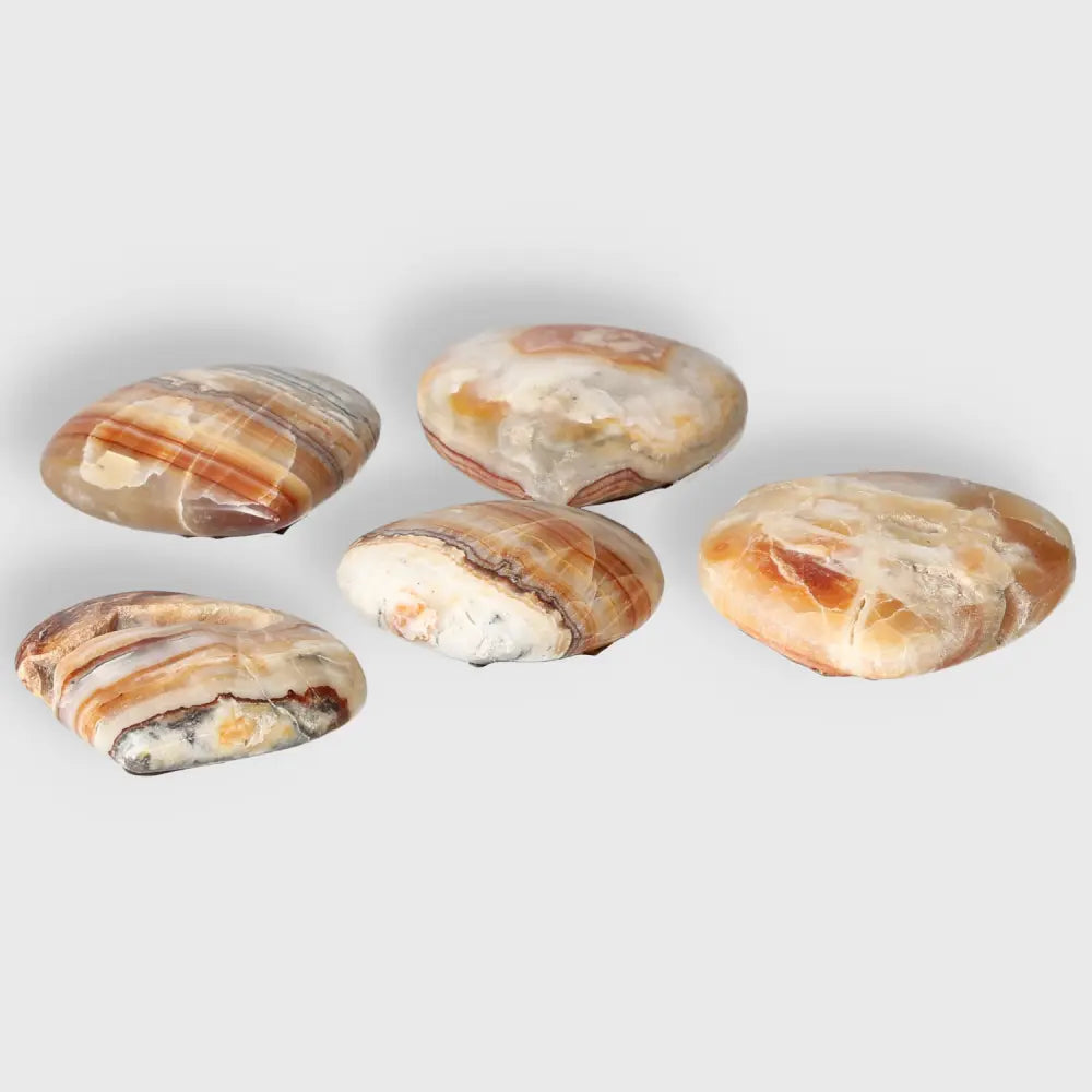 Smooth and polished Brown Aragonite palm stones with earthy tones, ideal for meditation and stress relief, showcase natural beauty and grounding energy.