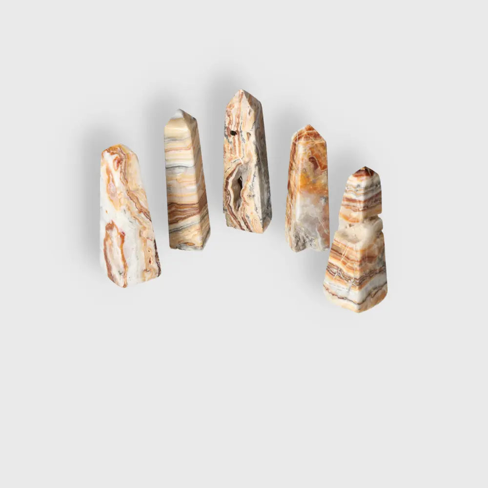 Five XL Brown Aragonite towers with earthy tones and natural patterns, showcasing their grounding energy and stabilizing properties.