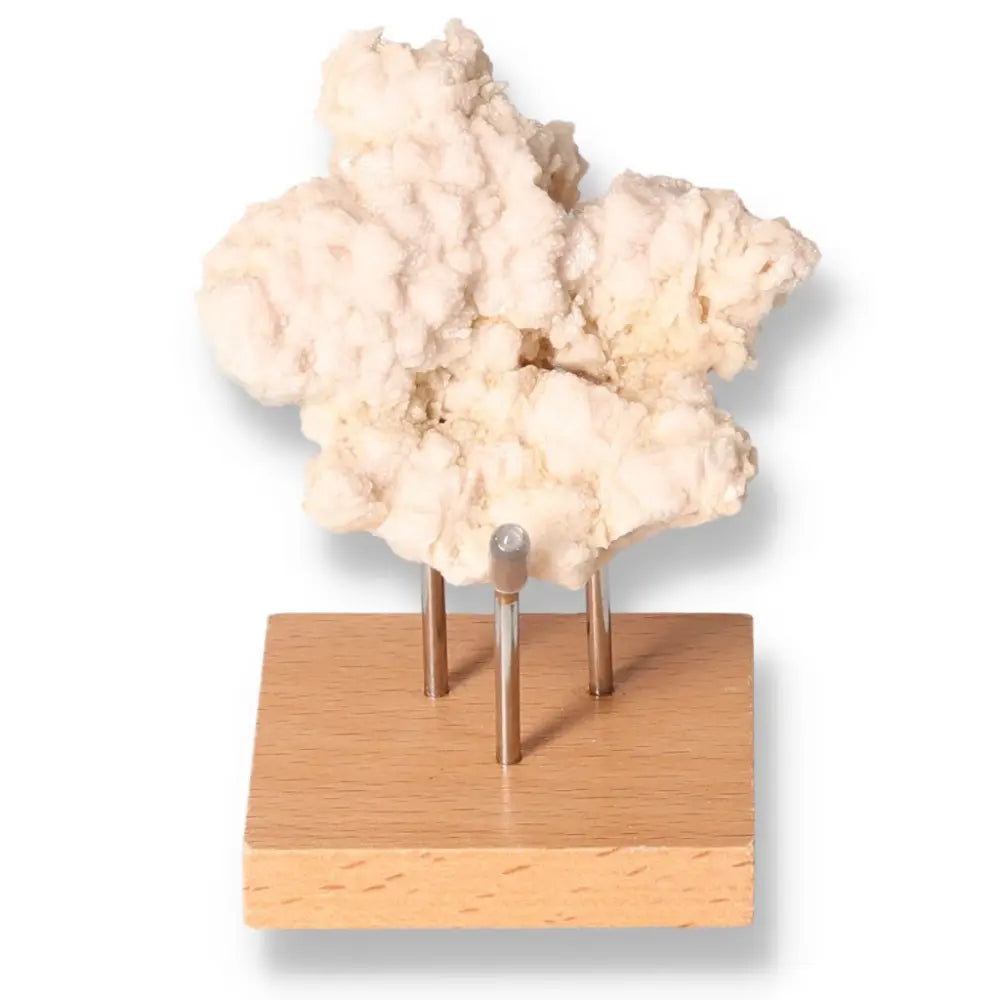 Calcite crystal on wooden stand, boosts self-confidence and motivation, enhances learning and concentration.