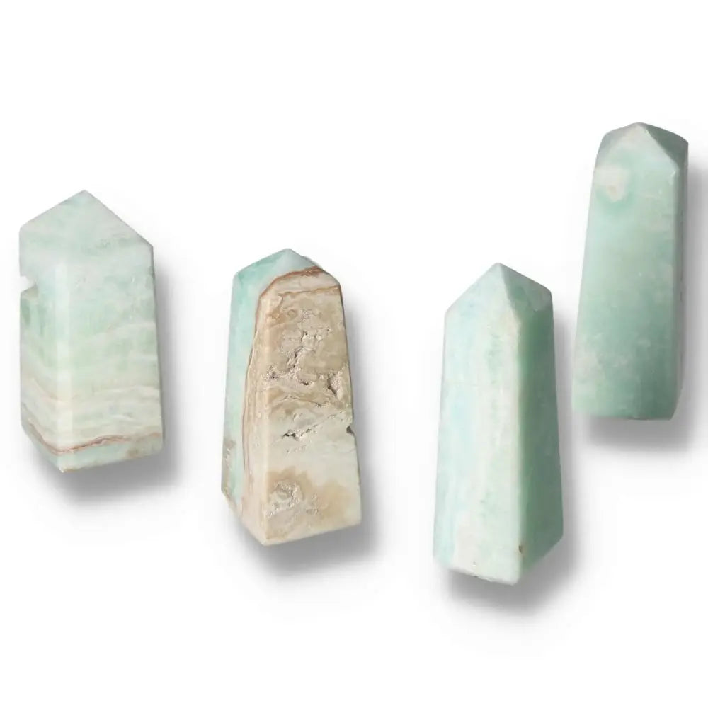 Four Caribbean Calcite towers with calming blue and creamy white shades from Sylvia Crystals, evoking ocean serenity and authenticity.