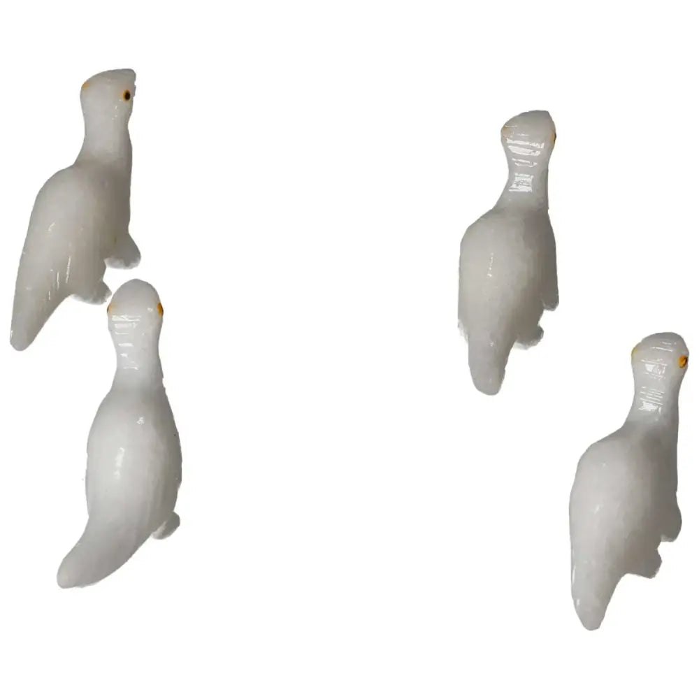 Four carved dolomite dinosaur figurines showcasing detailed craftsmanship from Sylvia Crystals.