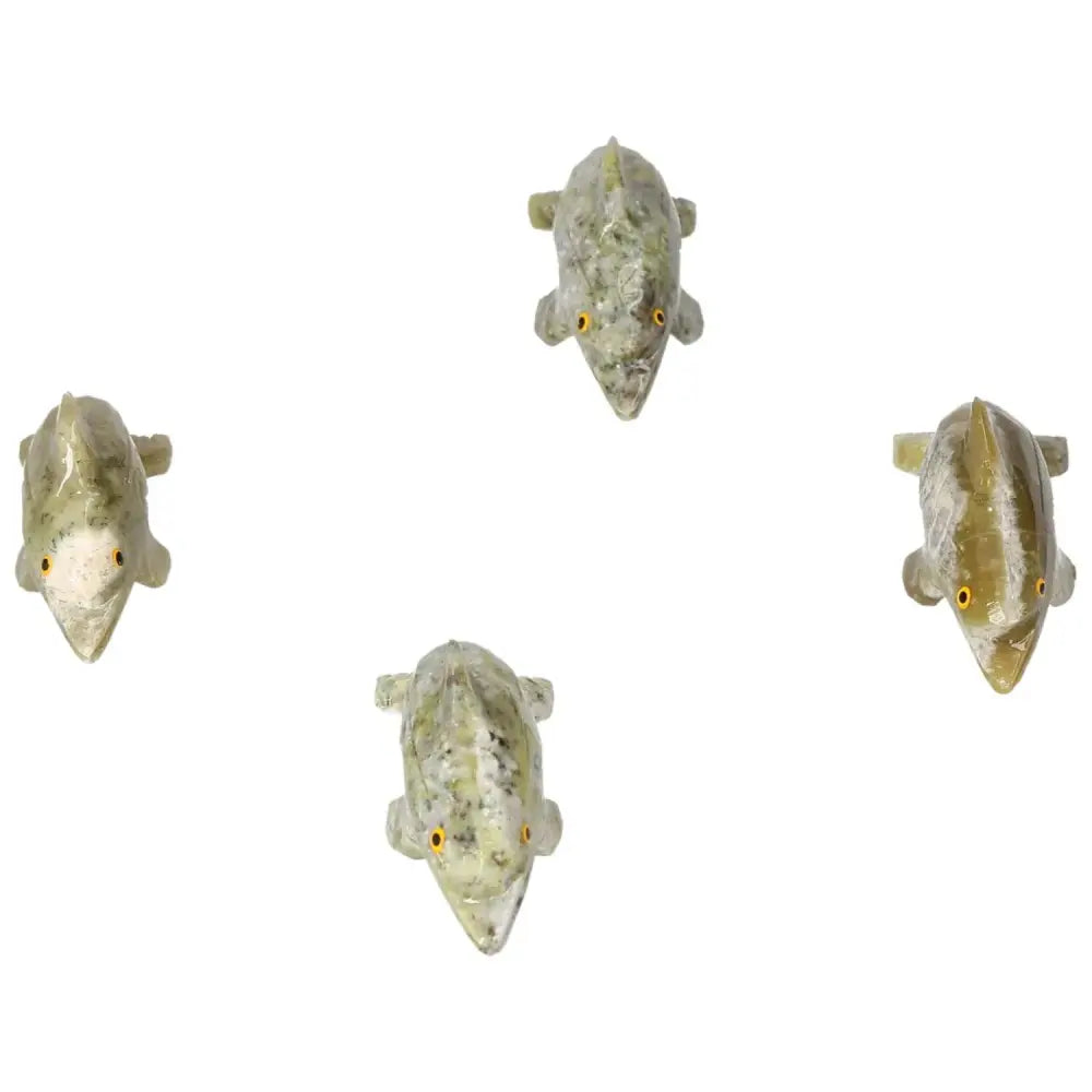 Four carved dolomite dolphin figurines with realistic details, showcasing the artistry and metaphysical properties of Sylvia Crystals.