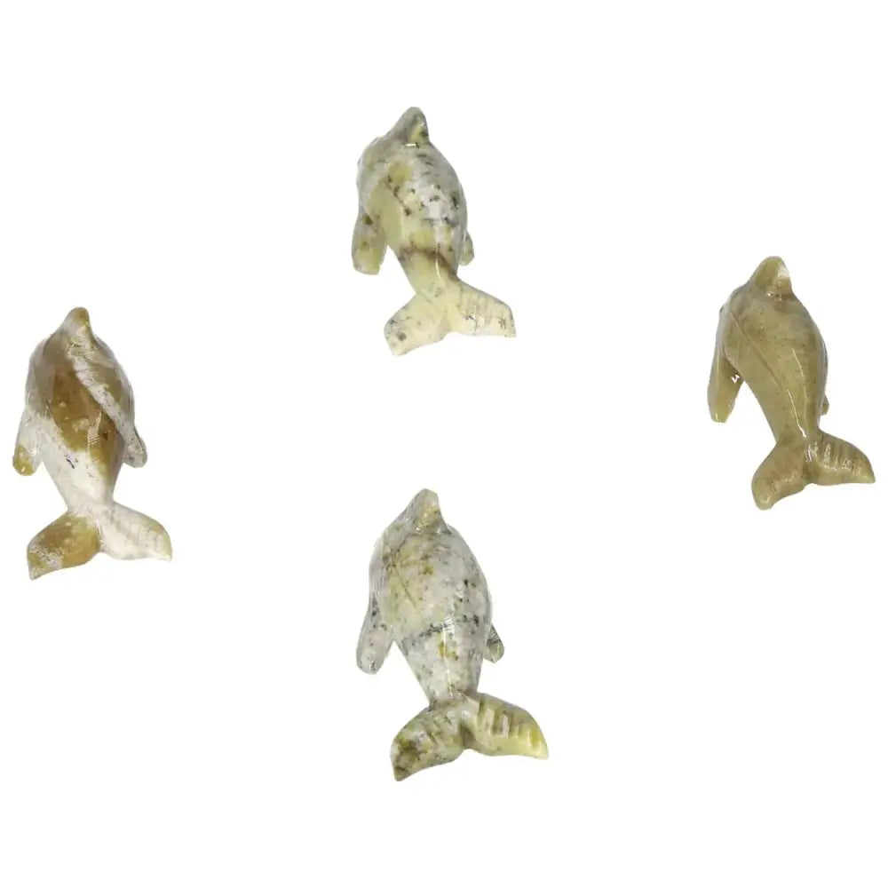 Four carved dolomite dolphins showcasing intricate craftsmanship, embodying metaphysical properties for emotional grounding and elegance.