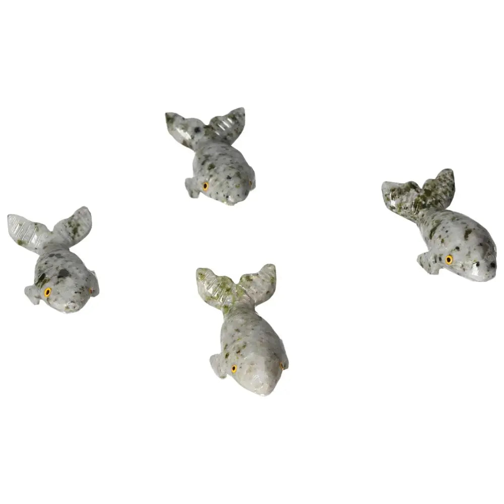 Four hand-carved dolomite whale sculptures, showcasing unique patterns and serene design, ideal for enhancing tranquility and elegance in decor.