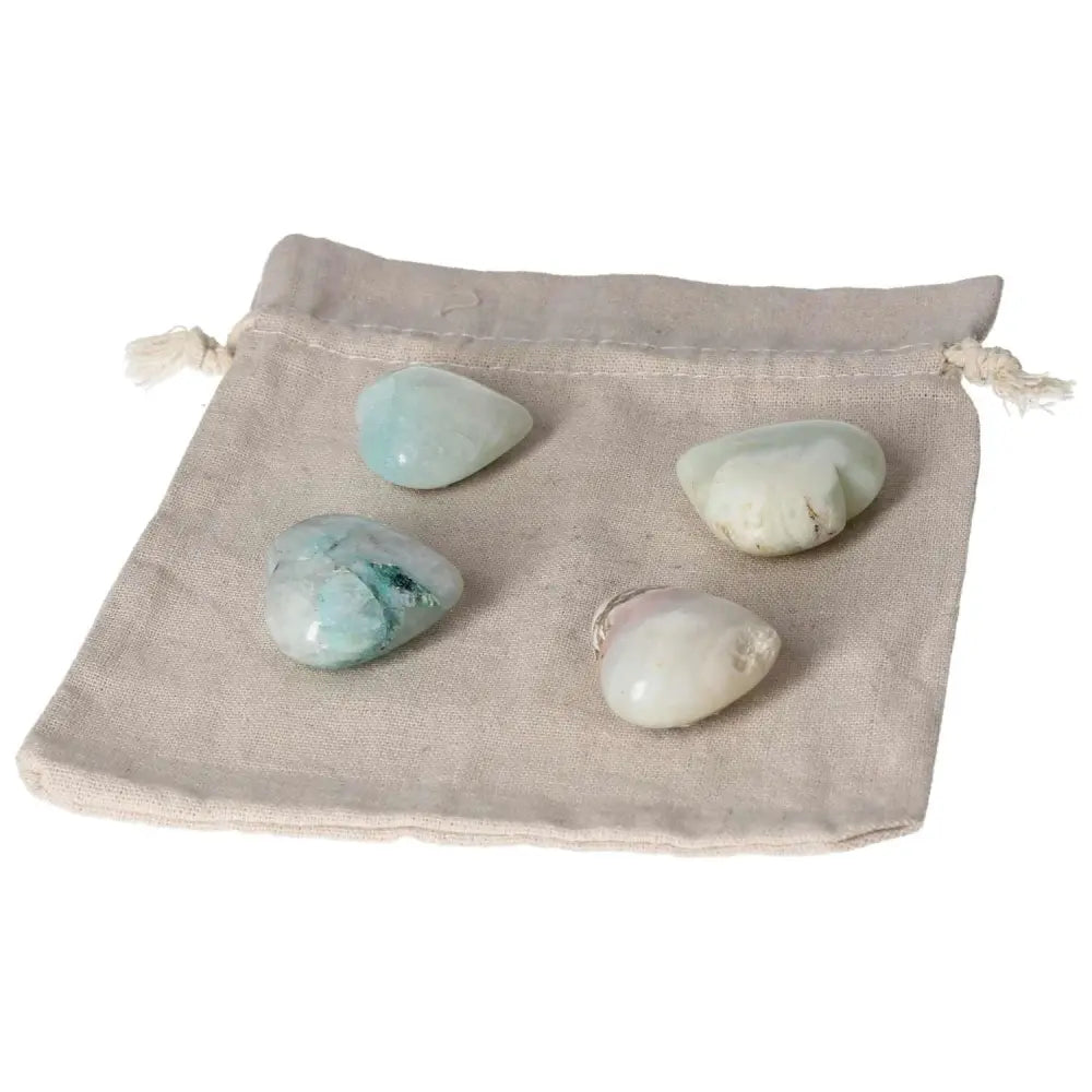 Four chrysocolla heart stones on a natural fabric bag, ideal for enhancing communication and understanding emotions