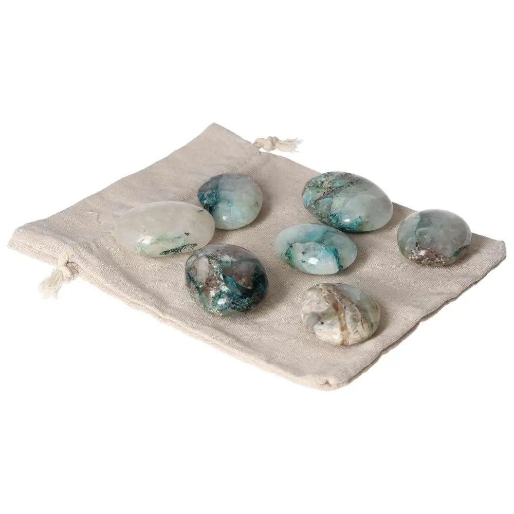 Collection of Chrysocolla palmstones on a linen bag, ideal for enhancing communication and embracing feminine energy.