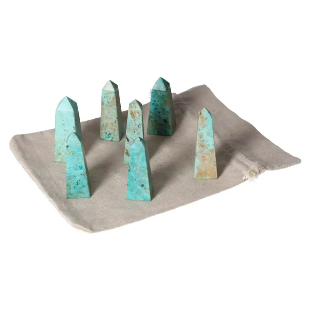 Chrysocolla towers displayed on a fabric mat, showcasing vibrant teal tones and feminine energy for communication and emotional understanding.