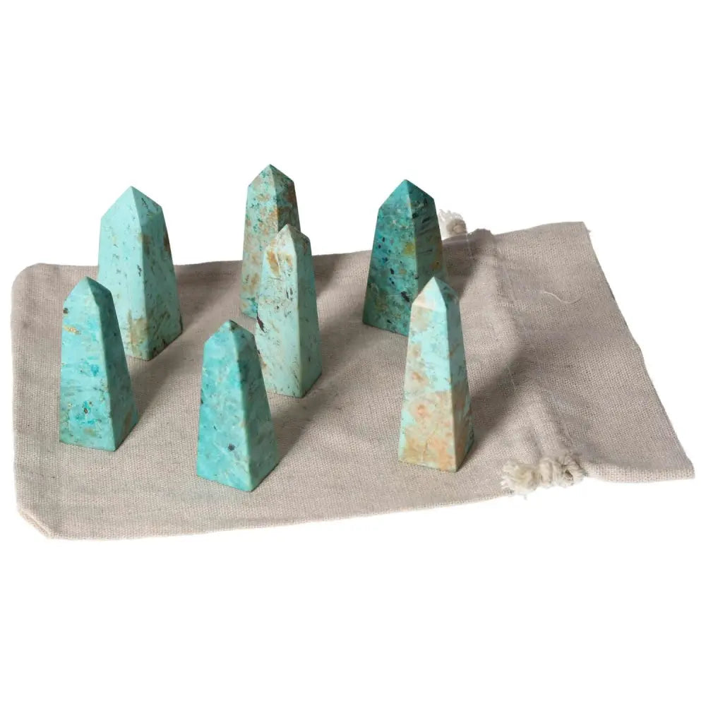 Set of chrysocolla towers on beige cloth, highlighting their vibrant hues and powerful feminine energy for enhancing communication.