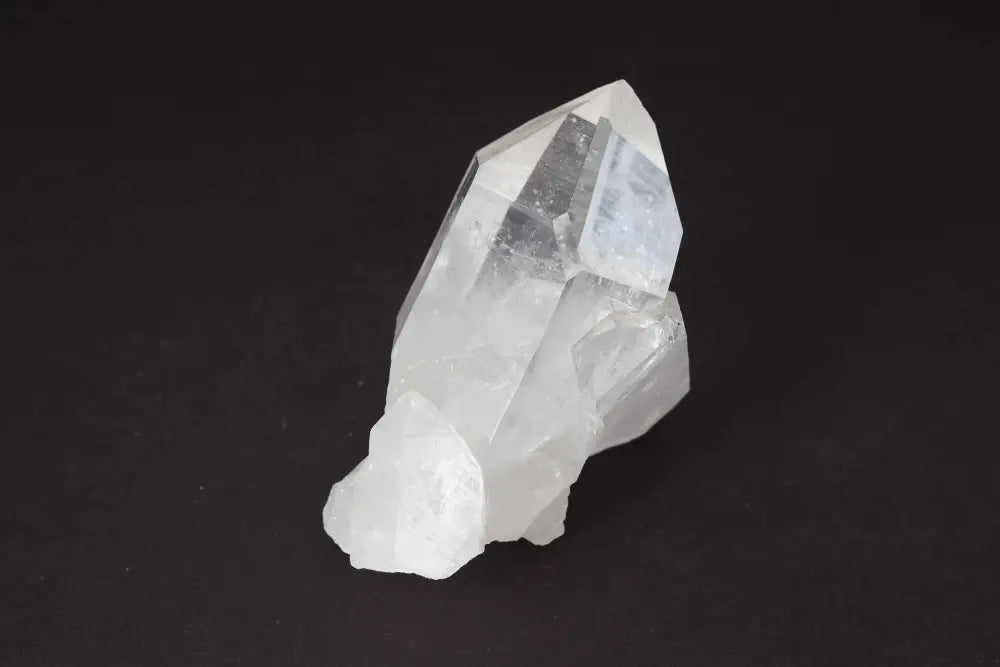 Clear Quartz Cluster crystal radiating clarity and high vibrational energy on a dark background, amplifying and purifying space.