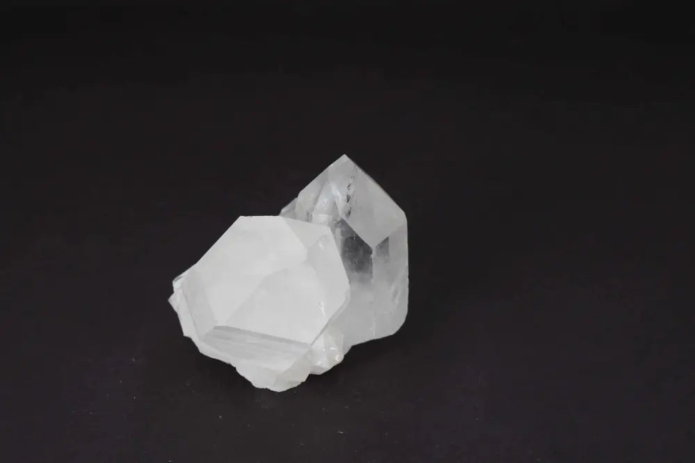 Clear Quartz cluster displaying multiple crystal points on a dark background, radiating high vibrational energy and clarity.