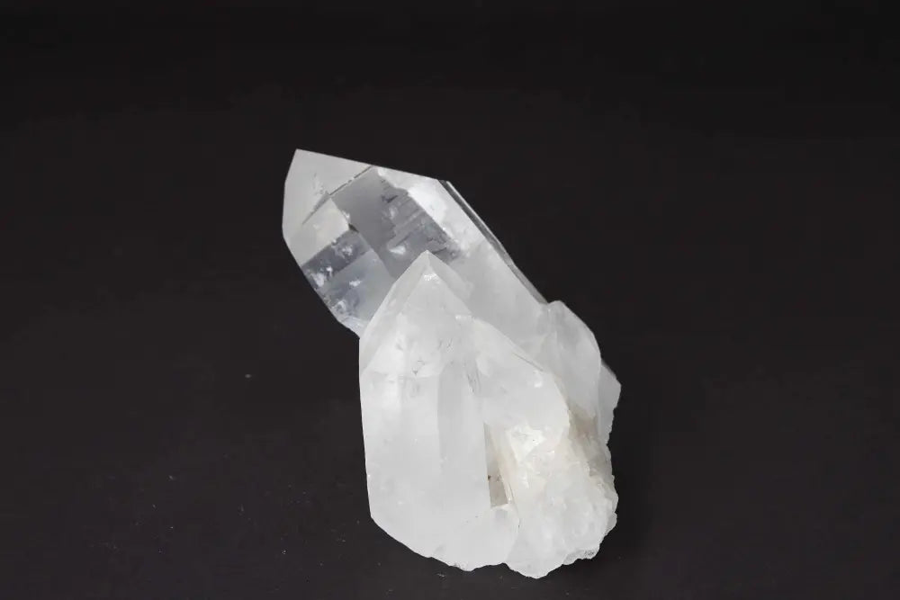 Clear Quartz Cluster on dark background, showcasing radiant, high vibrational energy and multiple crystal points for energy amplification.