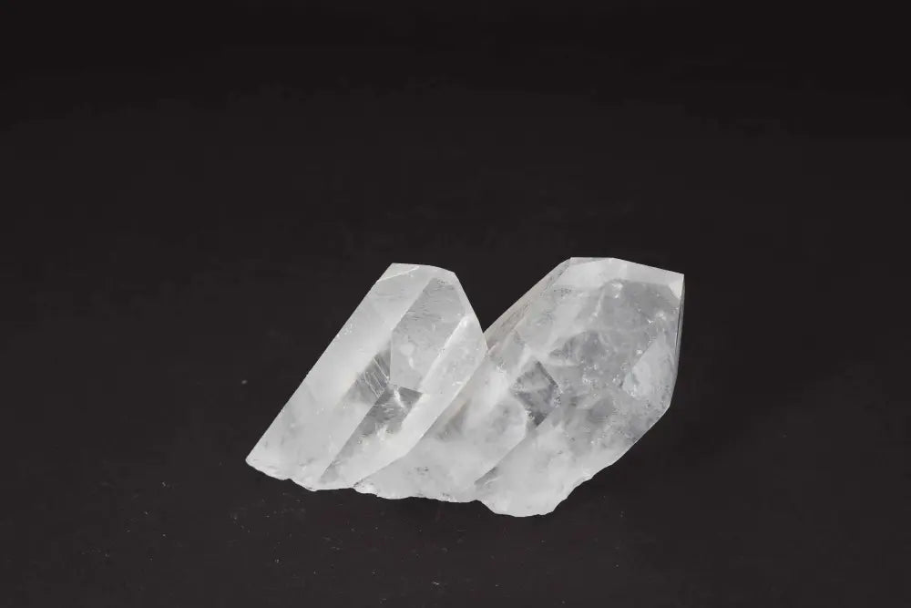 Clear Quartz Cluster with multiple crystal points, radiating clarity and amplifying energy, on a dark background.