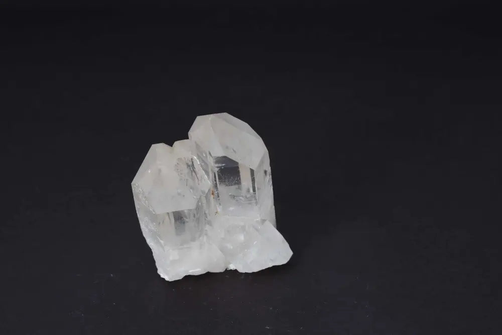 Clear Quartz Cluster on black background, showcasing natural crystal formations for amplifying energy and radiating clarity. Pure energy focus.