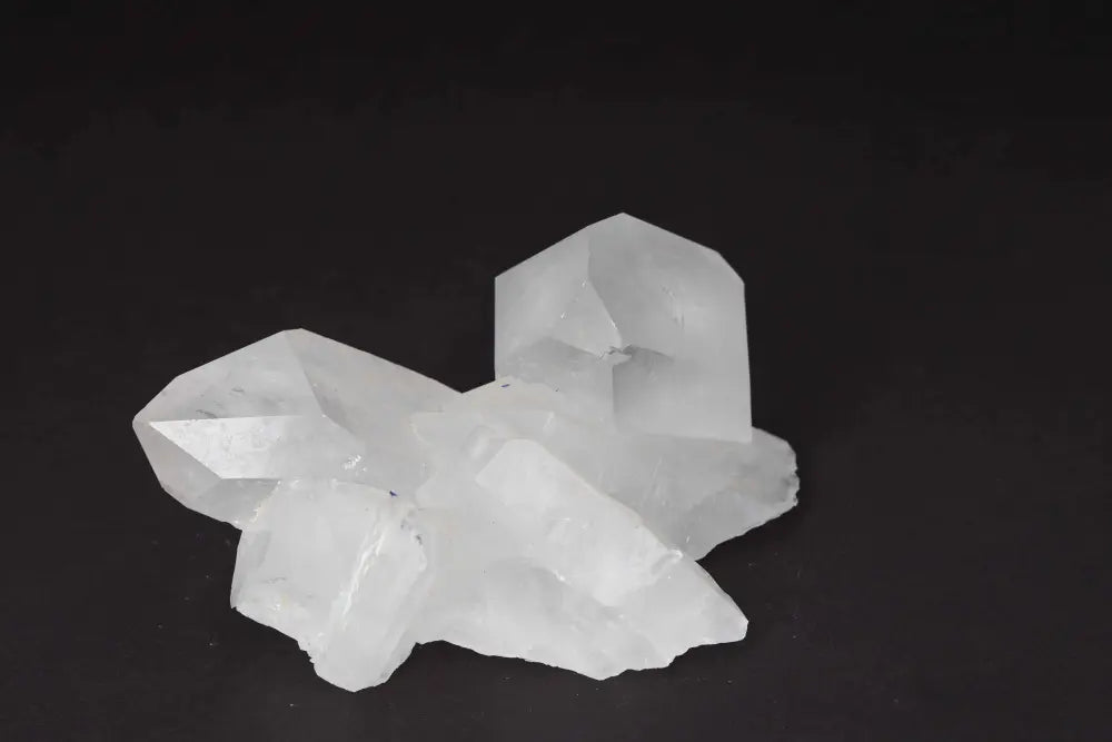 Clear Quartz Cluster with multiple crystal points, amplifying energy and purity, on a dark background.
