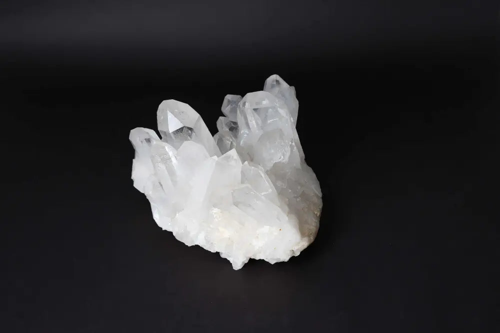 Clear Quartz Cluster radiating pure energy on a dark background, featuring multiple crystal points for amplified vibrational energy.