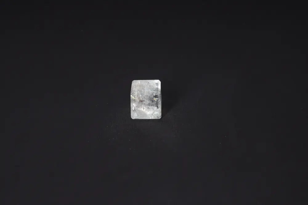 Clear Quartz Cube 2.5 cm on black background, known for purification and neutralizing negative vibrations and electromagnetic radiation.