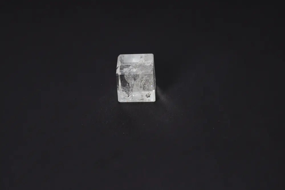 Clear Quartz Cube 3.5 cm on black background, known for purification, harmonizing energies, and neutralizing electromagnetic fields.