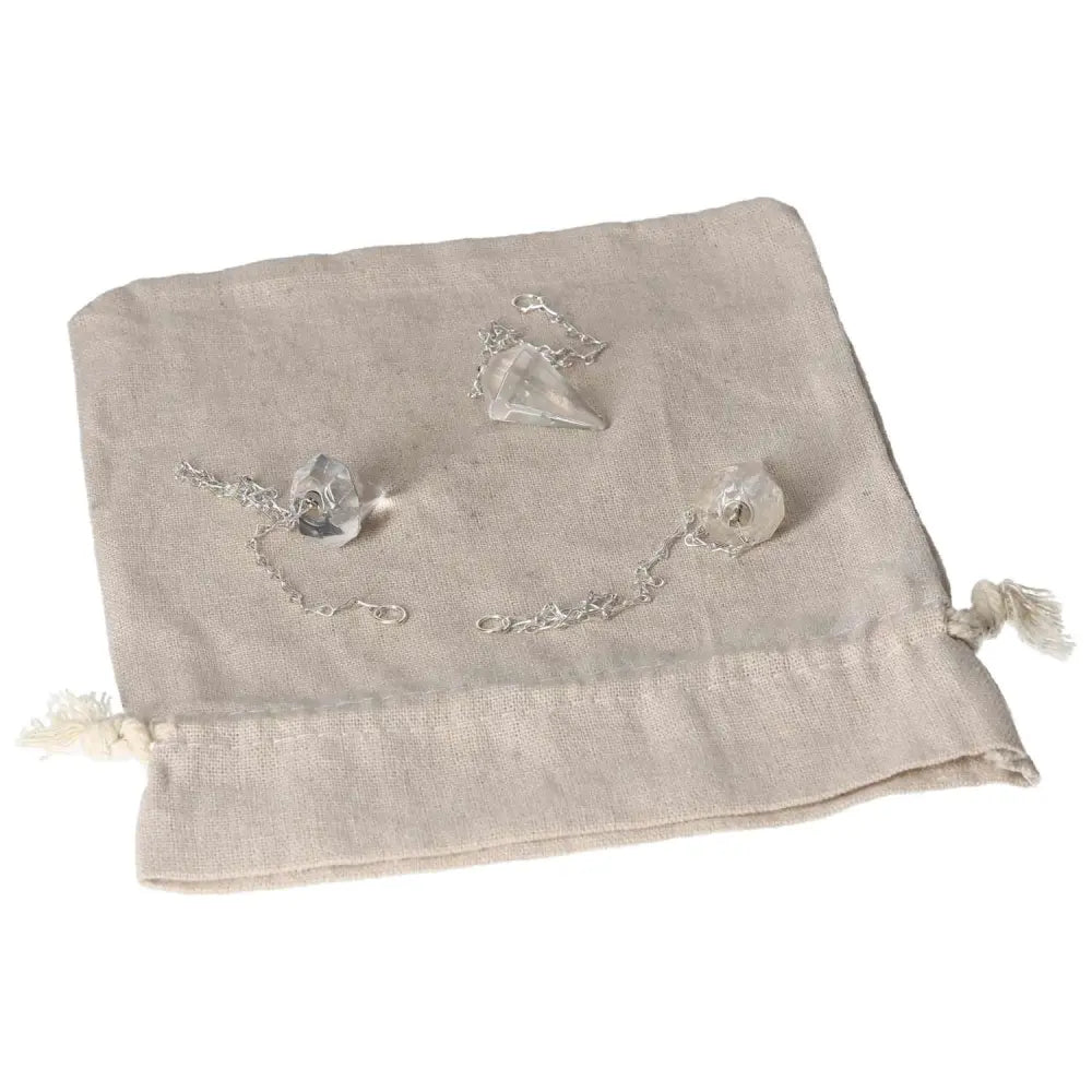 Clear Quartz pendulum with chain on a fabric pouch, ideal for harmonizing energy and purifying space.